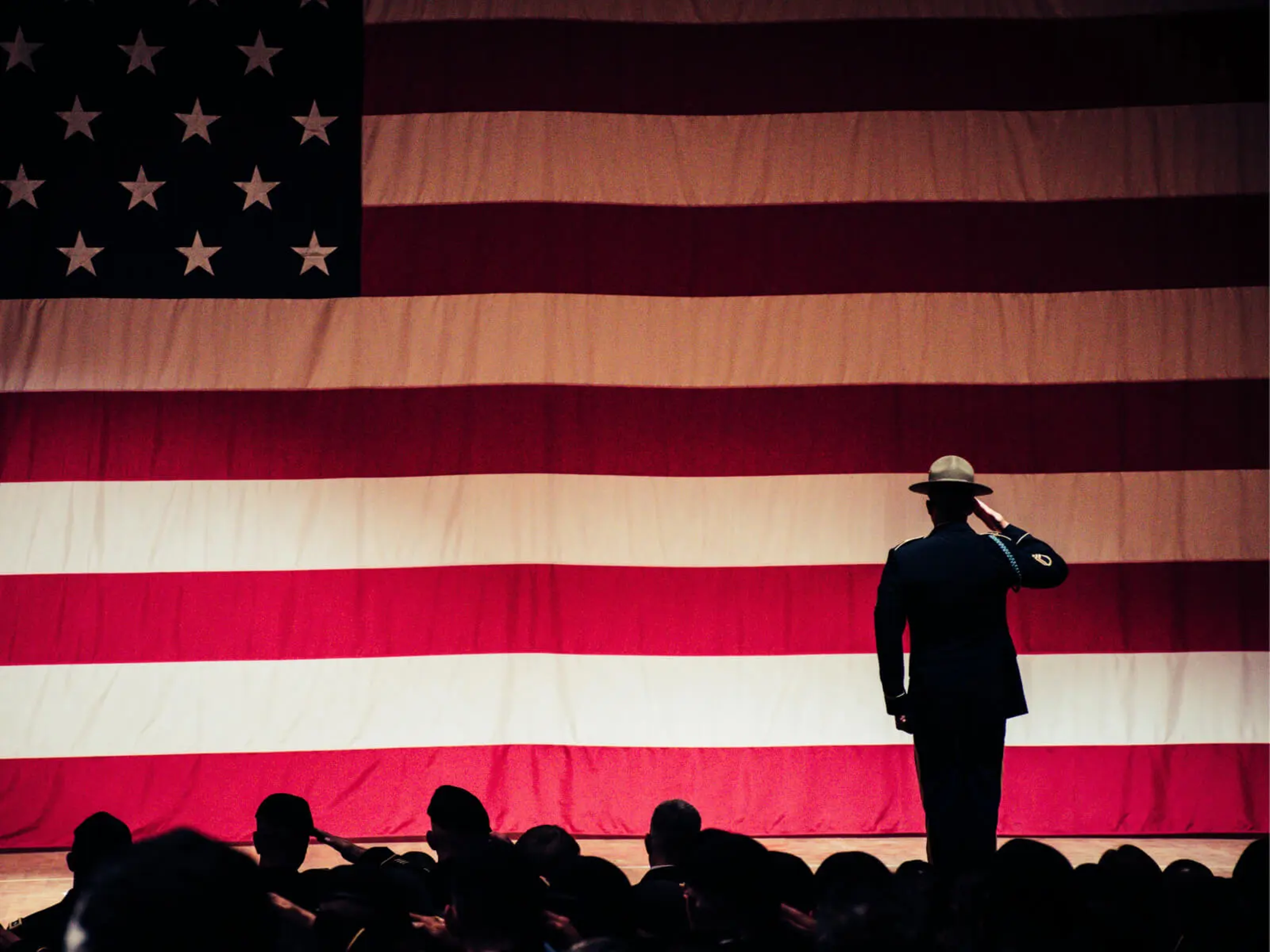 A soldier saluting the American flag.